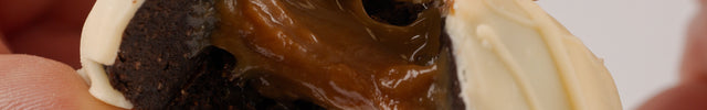 Close up of the Loada Balls White Caramel  protein ball opened up showing gooey caramel centre.