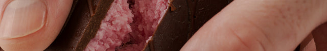 Close up of the Loada Balls Raspberry Coconut protein bar with its pink filling.