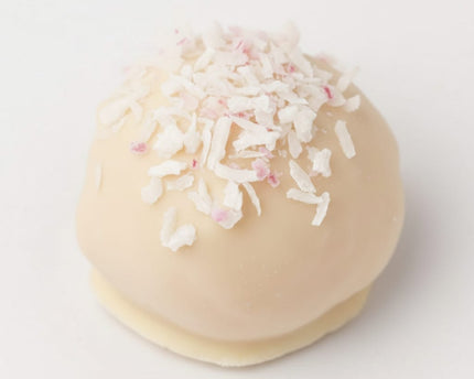 Close up of a single White Raspberry Coconut protein Ball from Loada Balls.